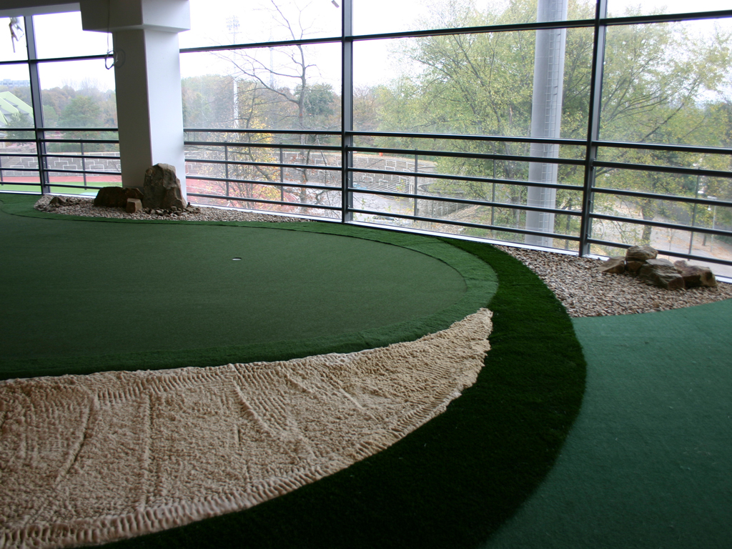 Indoor golf areas including chipping putting and driving on artificial golf turf